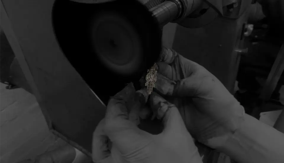 925 Sterling Silver badge being delicately hand polished by a skilled technician.