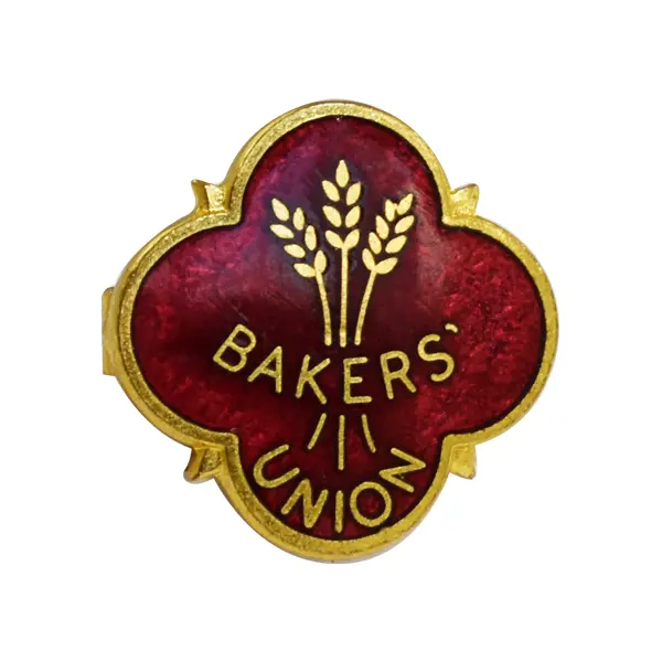 Die stamped, gold-plated Baker's union badge with enamel inlay.