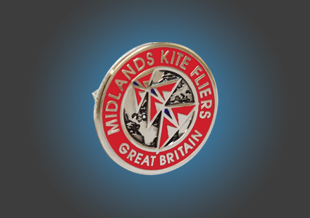 Die stamped, silver plated badge with multi tone enamel inlay.