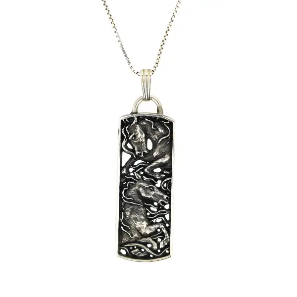 Die stamped, rounded rectangular pendant featuring wild horses.