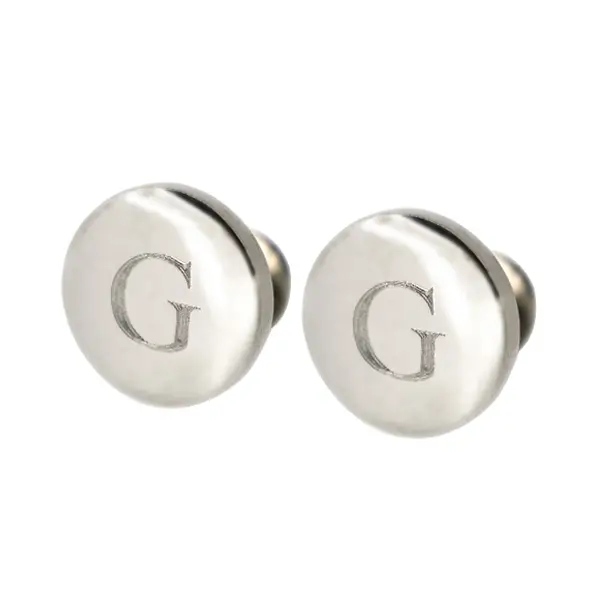 Circular disc cufflinks with an engraved initial "G."