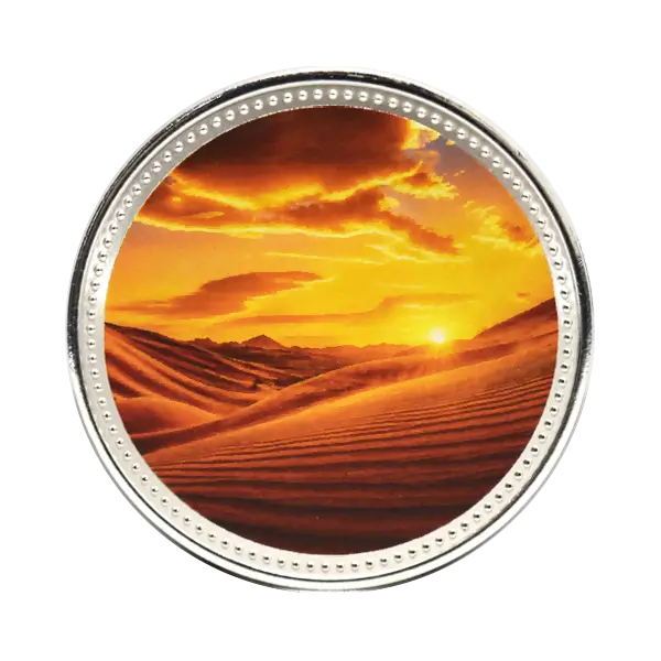 Silver commemorative coin with full-colour print showing desert dunes at sunset, 38.6mm diameter
